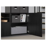 Armoire ouverte BESTÅ avec étagères réglables, rangeant des boîtes grises et des livres, montrant la gestion et l’organisation des câbles.