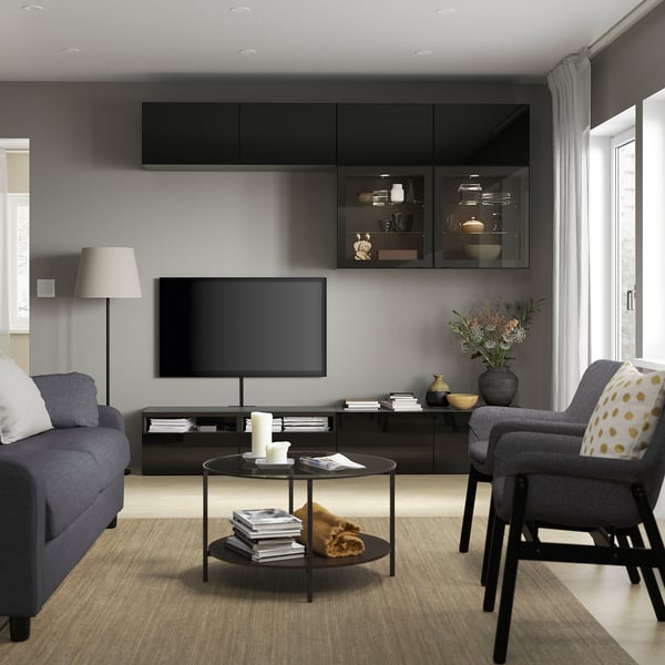 Salon moderne avec murs gris, télévision, canapé bleu et lampe.