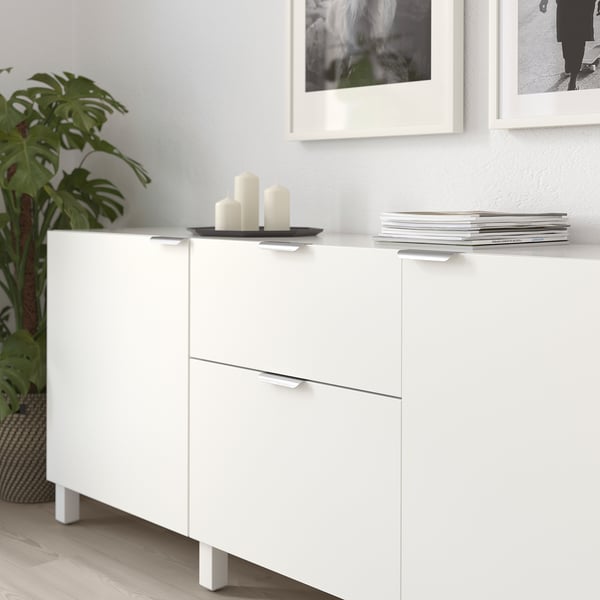 Armoire blanche avec poignées BILLSBRO, présentoir des chemises mensuelles, trois bougies sur le dessus.