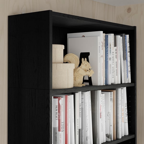 Étagère noire avec des livres et des objets décoratifs, maximise le rangement vertical, faisant partie de la série BLY.