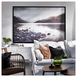 Grand art mural nature, lac noir et blanc, canapé blanc, table d’appoint en bois, vase vert.