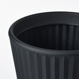 Jardinière cylindrique noire à rainures verticales. Plastique polyéthylène de haute qualité. Trou de vidange visible en bas.