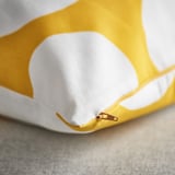 Housse de coussin jaune à pois blancs, fermeture éclair de qualité, détail en tissu recyclé.