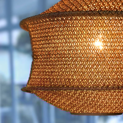 Suspension beige avec cordes de papyrus, lumière chaude.