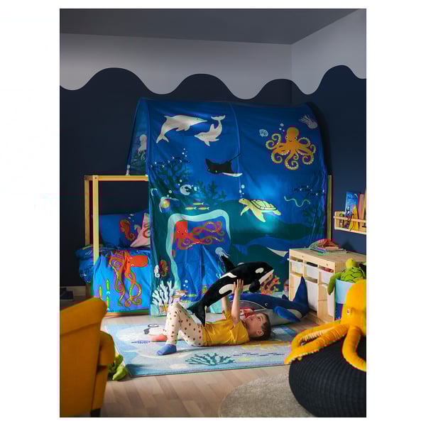 Chambre d’enfant sur le thème de l’océan avec tente, orque en peluche, chaise, jouets.