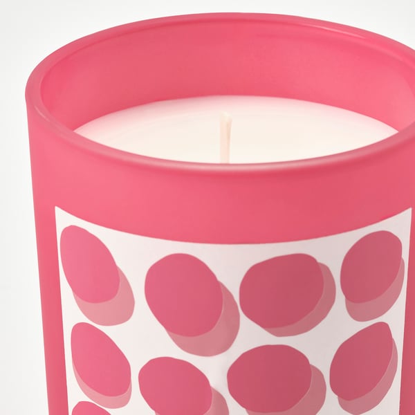 Bougie rose vif en verre à pois. Élégant et ludique, il remplit la pièce d’un parfum chaud de fraise et de vanille.