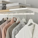Système d’étagères et de rails BOAXEL avec vêtements et couvertures.