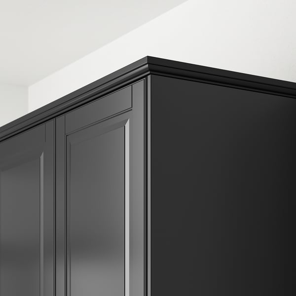 Les garnitures de cuisine noires, fixées au coin de l’armoire, dissimulent l’éclairage et les cordons.