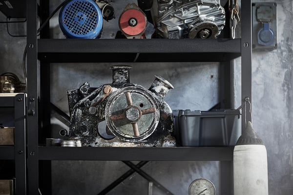 Étagères de rangement en métal noir contenant divers outils et équipements, soigneusement organisés.