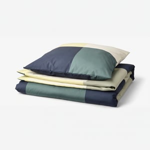 Literie BRUNKRISSLA en nuances bleu-vert avec motif à damiers, pliée soigneusement, en 54 % coton et 46 % viscose.