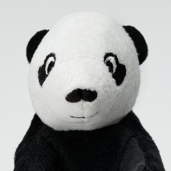 Cette image montre un panda en peluche de haute qualité, fabriqué à partir de polyester doux et recyclé. Il a cousu des yeux et un visage amical, parfait pour les câlins.