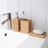 Lavabo de salle de bain moderne avec robinet chromé et accessoires en bois.
