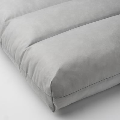 Coussin moelleux gris clair, soigneusement cousu, montrant une texture douce et de soutien.