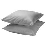Deux coussins argentés empilés, rectangulaires, tissu lisse.