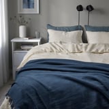 Plaid DYTÅG bleu, mélange lin-coton, design simple, taille moyenne sur le lit.