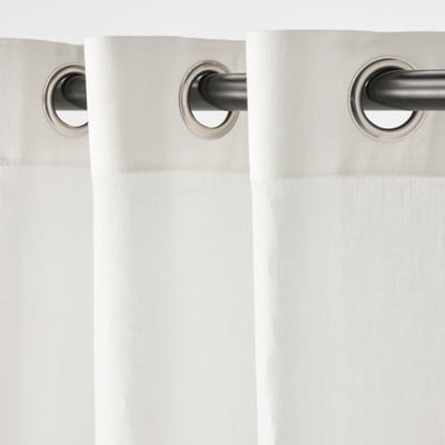 Présente deux rideaux en lin blanc froissé avec des en-têtes à œillets, conçus pour l’intimité et le filtrage de la lumière.