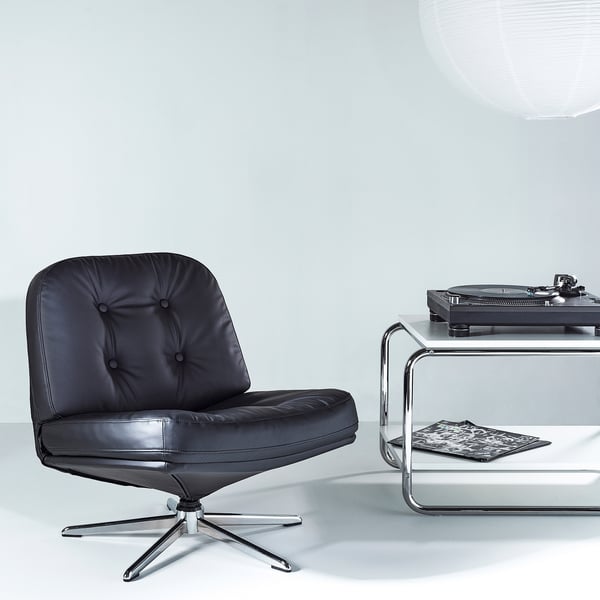 Chaise pivotante DYVLINGE noire avec assise/dossier en cuir, sous tourne-disque sur table en verre.