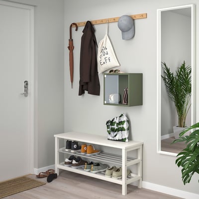 Entrée avec armoire à chaussures, porte-manteau et plante.