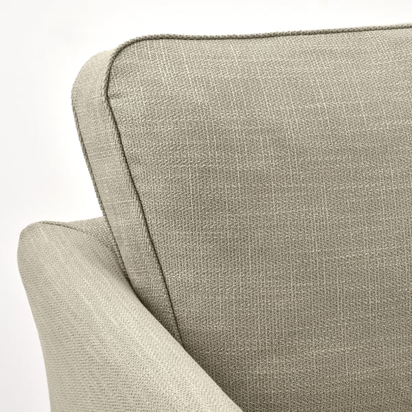 Gros plan d’un canapé confortable et de haute qualité avec une housse texturée et amovible présentant des coutures et un rembourrage.