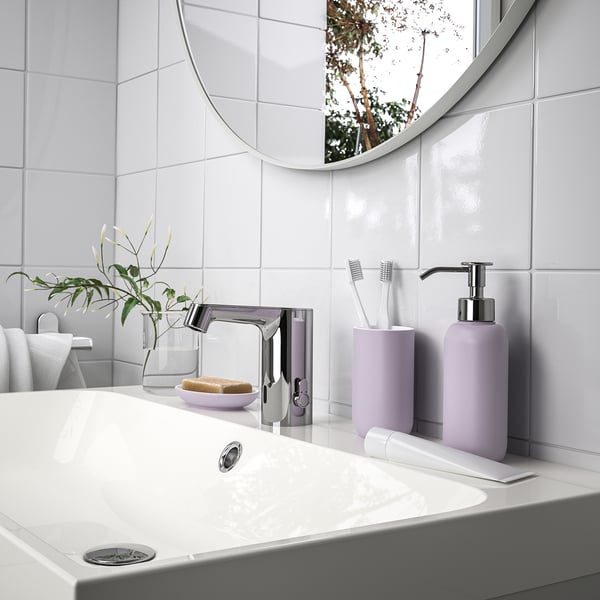 Évier blanc avec robinet chromé, miroir rond, savon à la lavande, série EKOLN et plante.