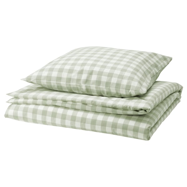 Une couette vichy vert et blanc, pliée, en coton biologique, fermeture enveloppe et fermetures métalliques.