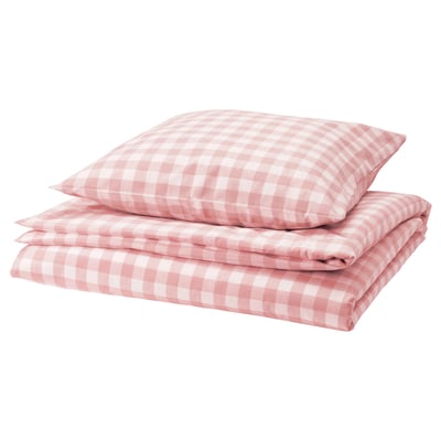 Une housse de couette à carreaux roses et blancs soigneusement empilée, en 100 % coton biologique.