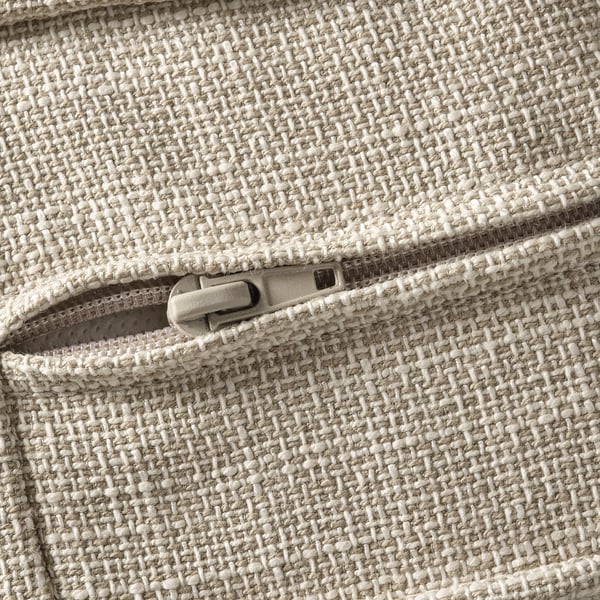 Gros plan d’une fermeture éclair de haute qualité sur un sac en tissu tissé de couleur crème avec une texture détaillée.