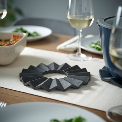 Pots en bambou noir sur table avec assiettes et verres.