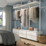 Armoire ELVARLI en blanc, organisée avec des vêtements, chambre bleue avec grande fenêtre