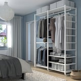 Le placard blanc ELVARLI dans la chambre à coucher permet de ranger les vêtements, les plis et les accessoires, plus haut que le lit, à côté de la fenêtre.