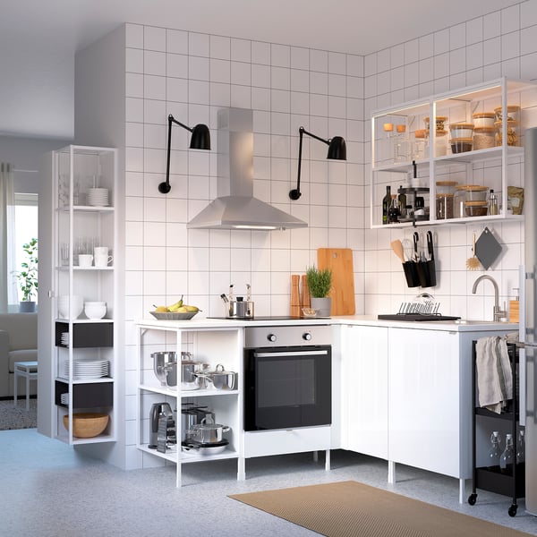 Cuisine blanche moderne avec étagères hautes et ouvertes, abat-jour noirs, cuisinière en acier inoxydable et divers ustensiles de cuisine.