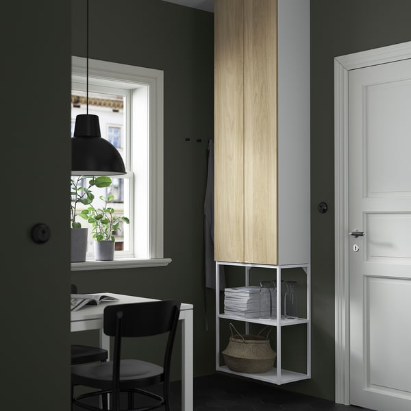 Unité de rangement ENHET dans un coin avec bocaux, panier, table et plante.