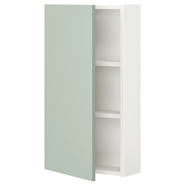 Une armoire murale ENHET blanche avec une porte gris-vert clair. Il dispose de deux étagères pour le rangement et a un design moderne et minimaliste.