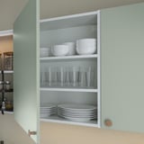 Armoire ouverte présentant des ustensiles de cuisine : bols, verres et assiettes soigneusement organisés sur des étagères.