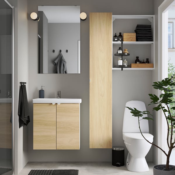 Salle de bain moderne : vanité ENHET, toilettes, douche en verre, miroir, plante, serviettes.