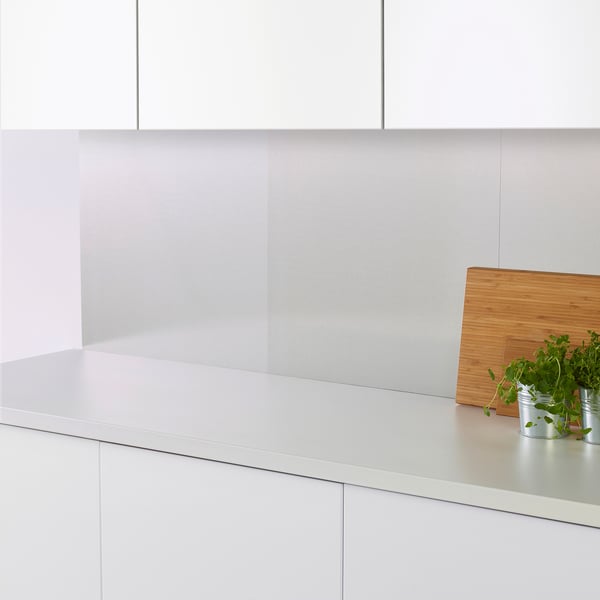 Cuisine moderne avec des murs et des comptoirs blancs propres. Petites plantes et planche de bois sur le comptoir, protégées par des panneaux muraux durables et faciles à nettoyer.