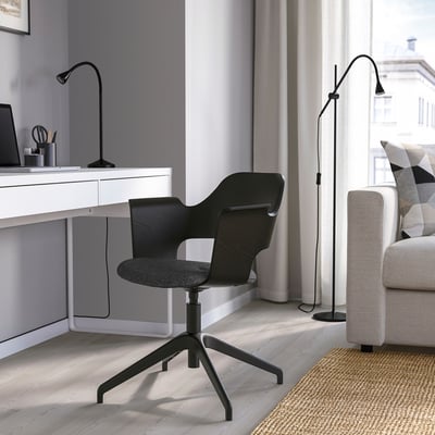 Bureau à domicile moderne avec chaise FJÄLLBERGET noire, bureau blanc, lampe, ordinateur portable et papeterie.