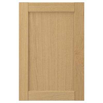 L’image montre une seule porte d’armoire FORSBACKA en chêne clair avec un cadre biseauté classique.