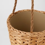 Panier en osier tressé à la main avec des poignées robustes, mettant en valeur un savoir-faire complexe et une texture naturelle.