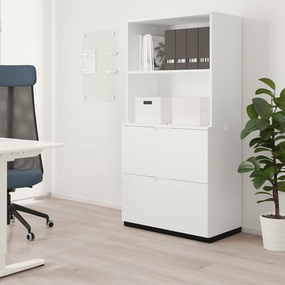 Armoire de bureau GALANT blanche moderne avec étagères et tiroirs. À côté d’une chaise bleue et d’une plante, idéale pour stocker des fournitures.