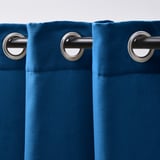 Rideaux bleu foncé avec œillets métalliques pour une suspension facile, offrant de l’intimité et une atténuation de la lumière.