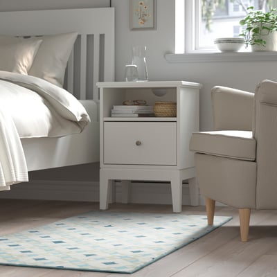 Chambre moderne avec tapis GOKVÄLLÅ, table de chevet et chaise.