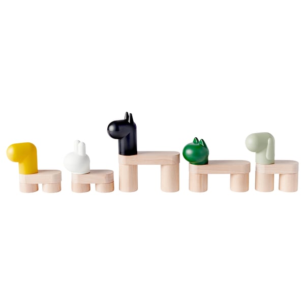 Cinq jouets colorés : jaune, blanc, noir, vert, gris, sur des supports en bois.