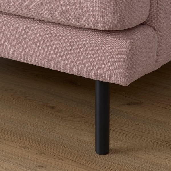 Gros plan d’un canapé rose rembourré d’assise et de jambe, mettant en valeur la texture du tissu et la conception robuste.