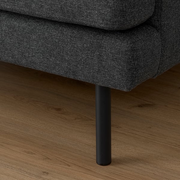 Gros plan du pied du canapé gris foncé sur le parquet. Montrant un design moderne et une construction de qualité.