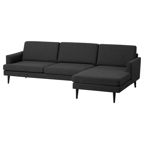 Canapé moderne gris foncé avec chaise, pieds minces, trois coussins de dossier, design accueillant.