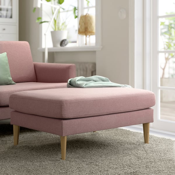 GRILLSTORP canapé et pouf en tissu rose. Design moderne du milieu du siècle. Doux, accueillant, avec des pieds en bois robustes. Couverture sur ottoman. Grande fenêtre derrière.