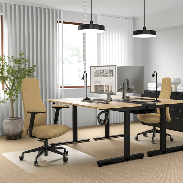 Bureau moderne avec deux chaises ergonomiques, deux écrans et une atmosphère lumineuse.