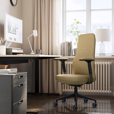 Bureau à domicile avec chaise GRÖNFJÄLL beige, bureau, ordinateur et lampe. La chaise est ergonomique, grande et rembourrée.