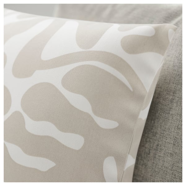 Coussin abstrait à motif de feuilles sur une surface rembourrée, texture douce, tissu en polyester recyclé.